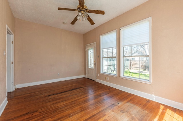 spare room featuring a ceiling fan, a textured ceiling, baseboards, and hardwood / wood-style floors