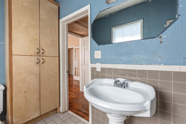 bathroom with a wainscoted wall and tile walls