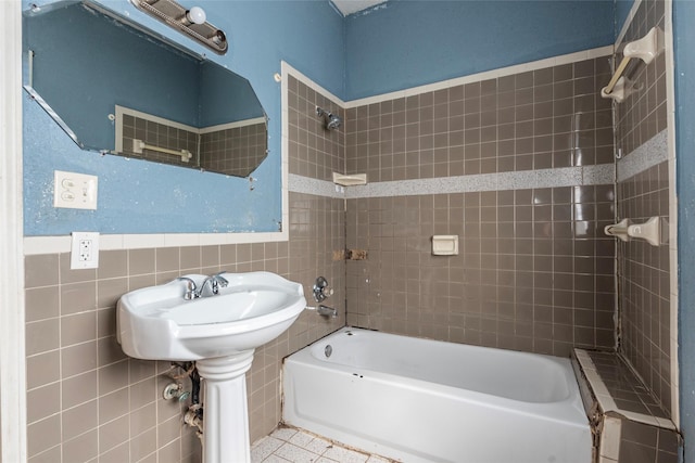 bathroom featuring tile patterned flooring, tile walls, and shower / tub combination