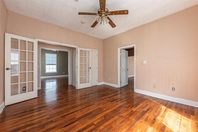 empty room featuring baseboards, ceiling fan, hardwood / wood-style floors, a textured ceiling, and french doors