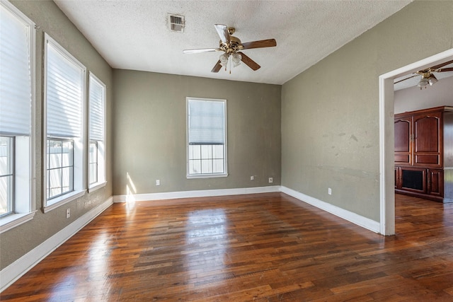 unfurnished room with baseboards, visible vents, ceiling fan, and hardwood / wood-style floors