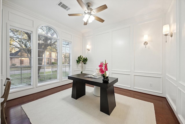 office space with visible vents, ceiling fan, crown molding, and a decorative wall