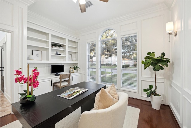 office with built in shelves, a ceiling fan, plenty of natural light, ornamental molding, and a decorative wall