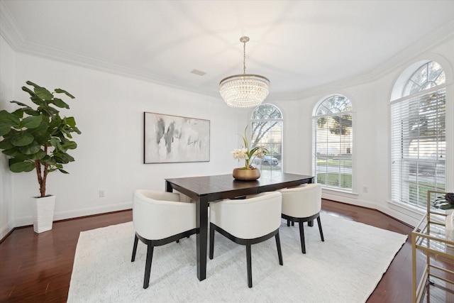 dining space with a notable chandelier, dark wood-type flooring, and ornamental molding