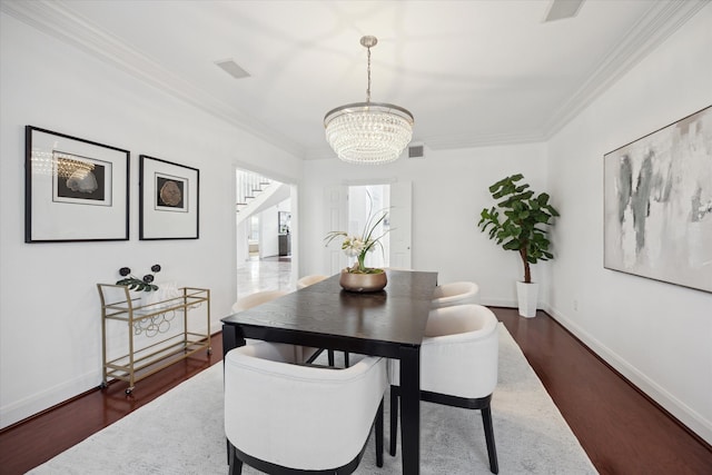 dining space featuring crown molding, dark wood-style floors, visible vents, and a chandelier