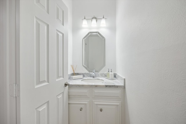 bathroom featuring vanity and a textured wall