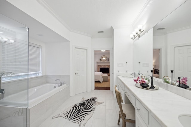 ensuite bathroom with ornamental molding, a sink, connected bathroom, a fireplace, and double vanity