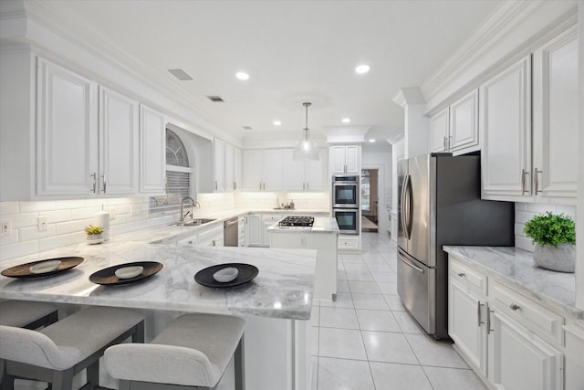 kitchen with light tile patterned floors, a peninsula, a sink, white cabinets, and appliances with stainless steel finishes