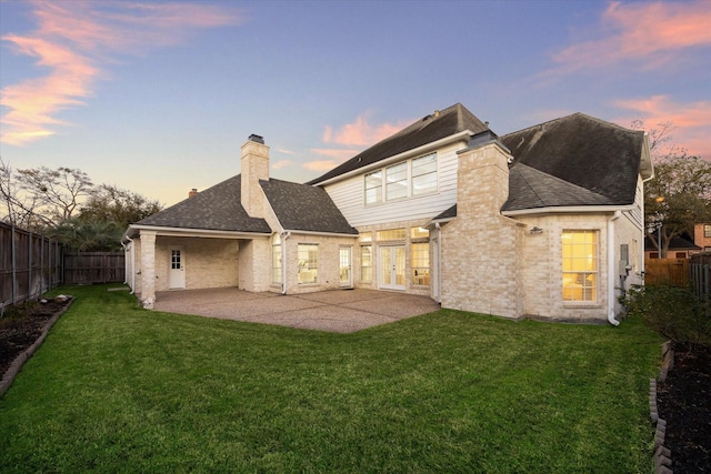 rear view of property with a patio, a fenced backyard, and a chimney