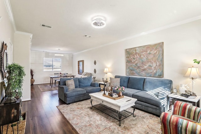 living area with baseboards, visible vents, crown molding, and wood finished floors