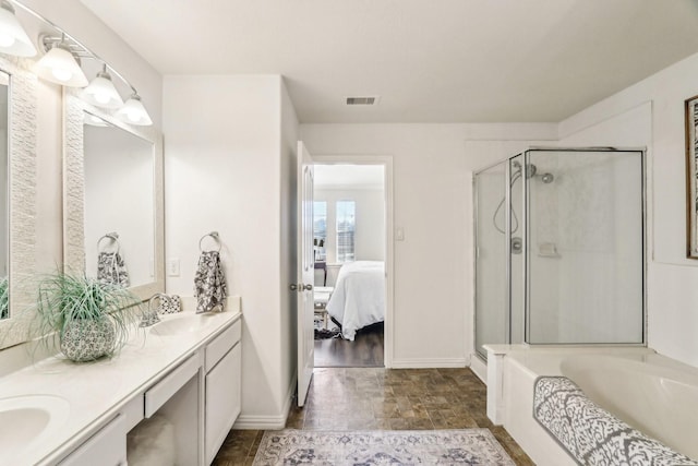 ensuite bathroom with visible vents, a sink, a shower stall, and ensuite bathroom