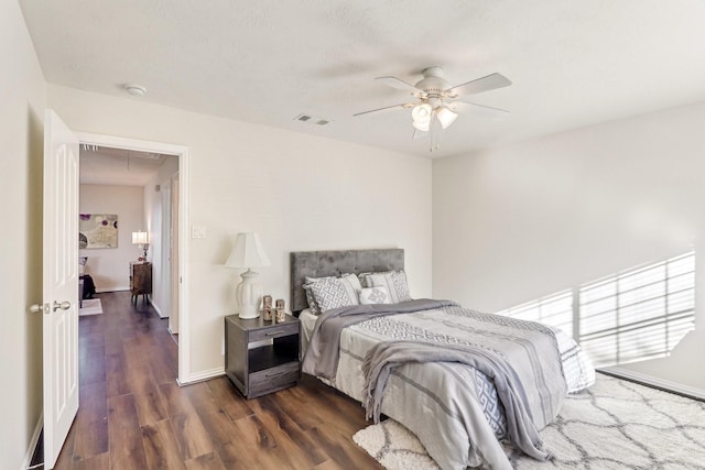 bedroom featuring dark wood-type flooring, visible vents, ceiling fan, and baseboards