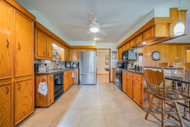 kitchen with a sink, a ceiling fan, black appliances, and brown cabinetry