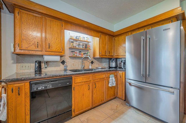 kitchen featuring brown cabinetry, black dishwasher, high quality fridge, and a sink