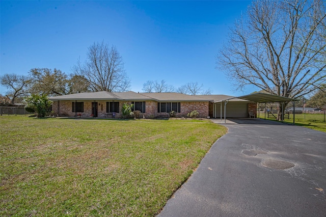 ranch-style home with fence, driveway, a carport, a front lawn, and brick siding