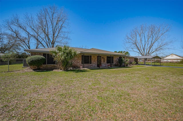 rear view of property featuring a yard, brick siding, a carport, and fence