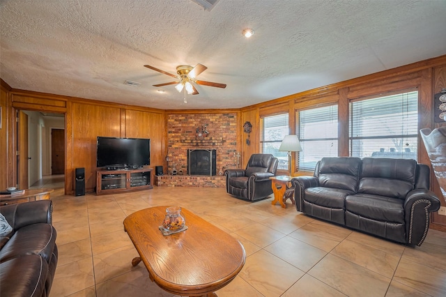 living room with light tile patterned floors, visible vents, a fireplace, and a ceiling fan