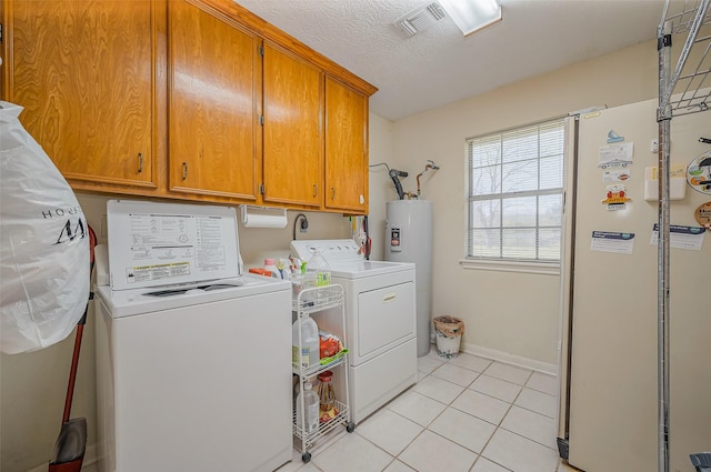 laundry area with light tile patterned flooring, cabinet space, separate washer and dryer, water heater, and a textured ceiling