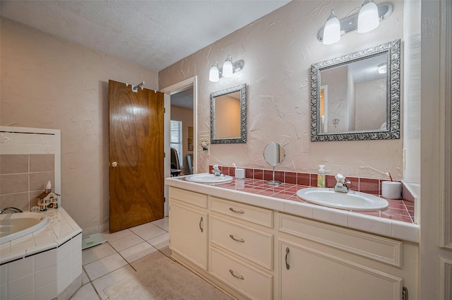 bathroom featuring tile patterned floors, double vanity, a textured ceiling, and a sink