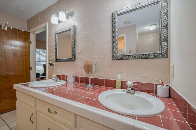 full bath with double vanity, visible vents, and a sink