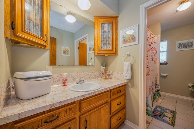 full bathroom featuring vanity, baseboards, and tile patterned flooring