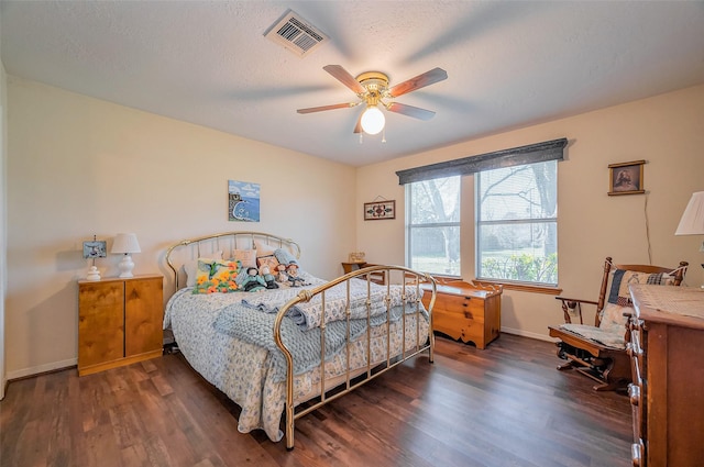 bedroom featuring visible vents, ceiling fan, baseboards, wood finished floors, and a textured ceiling