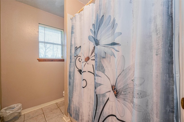 full bath with tile patterned flooring, curtained shower, toilet, and baseboards