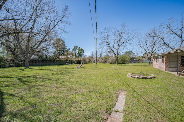 view of yard featuring a playground and fence