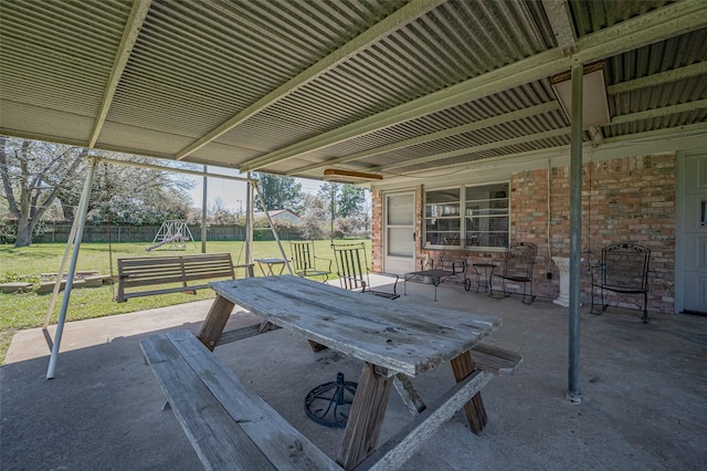 view of patio with outdoor dining area, fence, and a playground