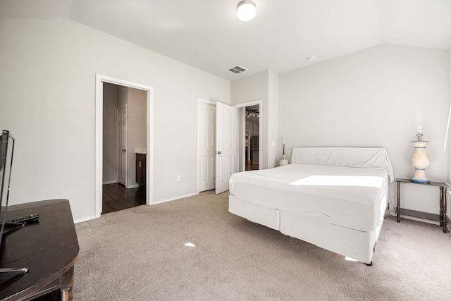 bedroom with lofted ceiling, light carpet, visible vents, and baseboards