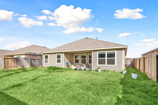 back of house with a fenced backyard, a yard, and roof with shingles