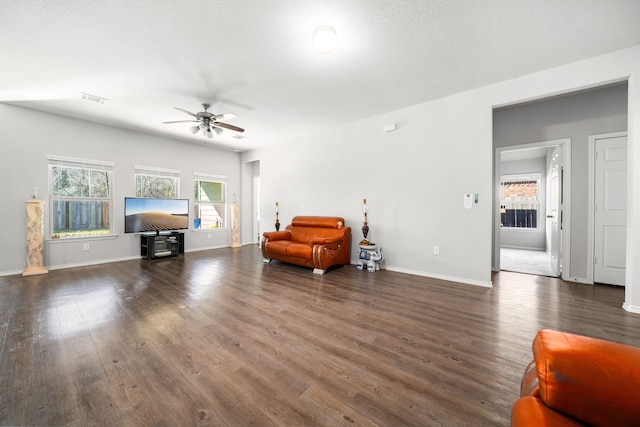 living area with visible vents, ceiling fan, baseboards, and wood finished floors