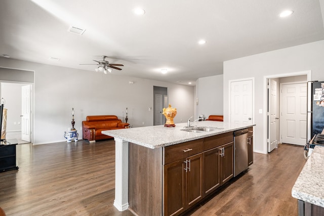 kitchen featuring dark wood finished floors, recessed lighting, stainless steel dishwasher, open floor plan, and a sink