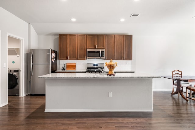 kitchen featuring visible vents, appliances with stainless steel finishes, washer / clothes dryer, and dark wood-style flooring