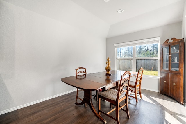 dining room featuring vaulted ceiling, dark wood finished floors, and baseboards