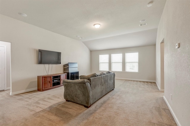 living area with light carpet, lofted ceiling, visible vents, and baseboards