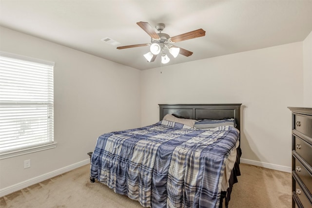 bedroom featuring baseboards, visible vents, light colored carpet, and multiple windows