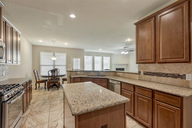kitchen with tasteful backsplash, light stone countertops, a ceiling fan, and stainless steel appliances