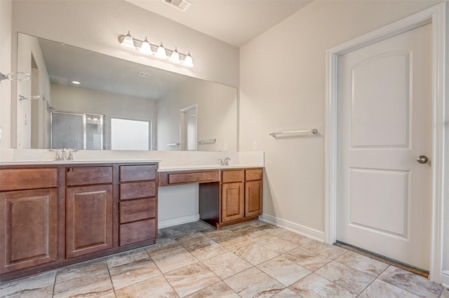 bathroom featuring double vanity, a shower stall, baseboards, and a sink