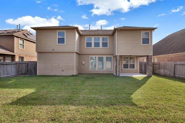 back of house featuring a yard, a patio area, and a fenced backyard
