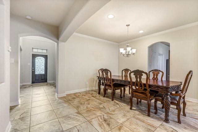 dining space featuring baseboards, arched walkways, a notable chandelier, and crown molding