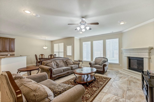 living room featuring ceiling fan, baseboards, ornamental molding, and recessed lighting