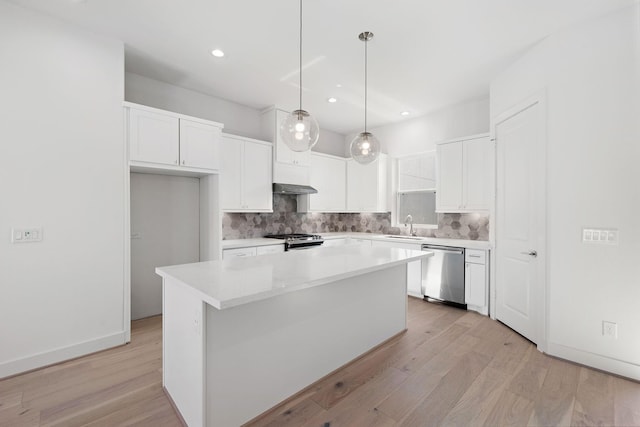 kitchen with light wood-style flooring, a kitchen island, stove, white cabinetry, and stainless steel dishwasher