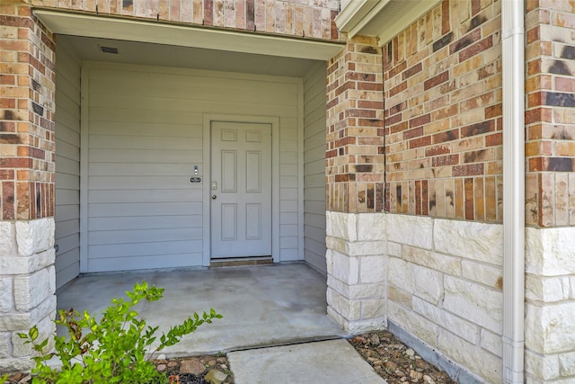 property entrance featuring brick siding