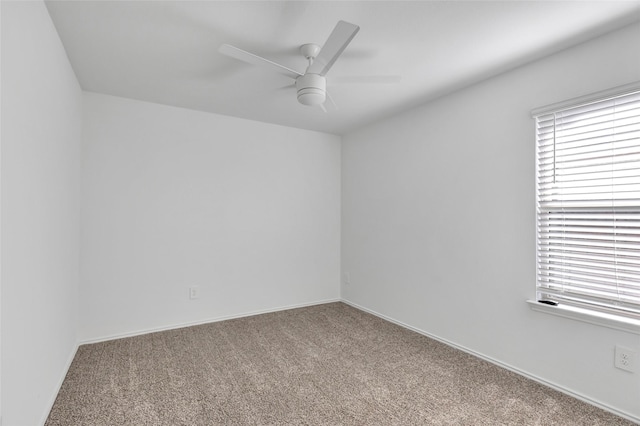 empty room with ceiling fan, baseboards, and carpet