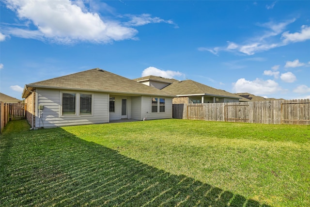 back of property with a lawn and a fenced backyard