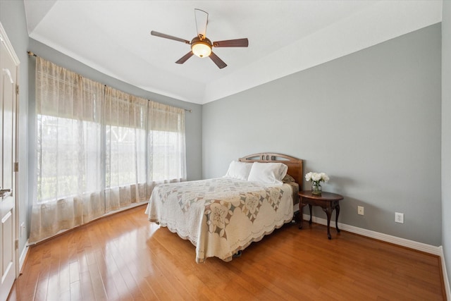 bedroom featuring light wood finished floors, ceiling fan, and baseboards