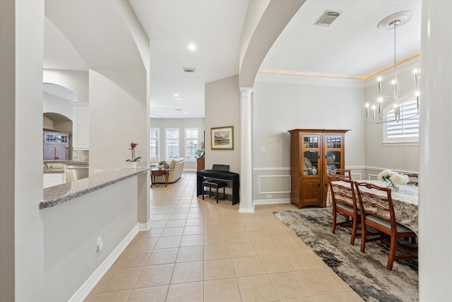 dining room featuring light tile patterned floors, visible vents, arched walkways, and a notable chandelier