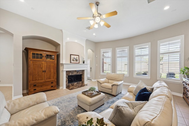 living room with arched walkways, a healthy amount of sunlight, and light tile patterned flooring