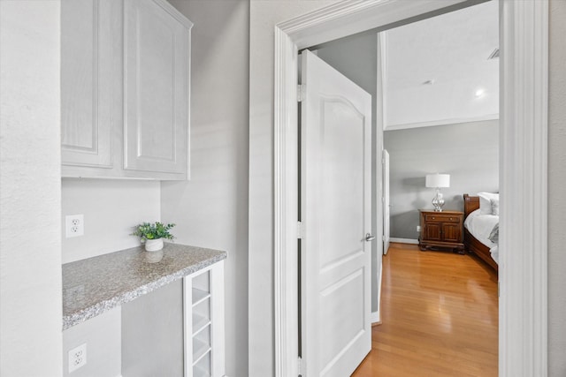 corridor with baseboards and light wood-type flooring